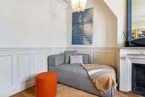 een woonkamer met een stoel en een open haard bij GuestReady - Estadia na moda em Saint-Mandé in Saint-Mandé