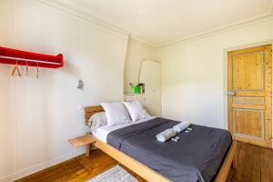 Un dormitorio con una cama grande con marco de madera. en Trendy staycation in Saint-Mandé, en Saint-Mandé
