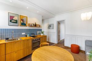 cocina con mesa de madera y fregadero en Trendy staycation in Saint-Mandé, en Saint-Mandé 5 fotos más