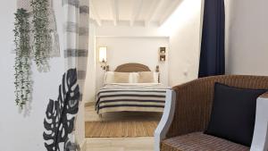 a bedroom with a bed and a chair at POSIDONIO old town apartment in Villajoyosa