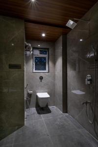 a bathroom with a shower and a toilet and a sink at Hotel Aura Inn Airoli ,Digha in Navi Mumbai