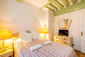 um quarto com uma cama com duas almofadas em GuestReady - Parisian bliss near the Louvre Museum em Paris
