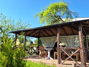 einen hölzernen Pavillon mit einem Dach auf einer Terrasse in der Unterkunft Kraavi Guest Hostel in Kuressaare