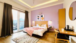 a bedroom with a bed and a desk and a window at BluO Medicity - Boutique Hotel Gurgaon in Gurgaon