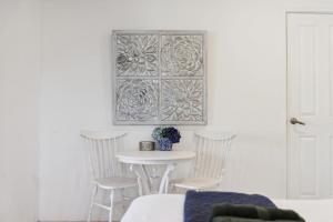 a table and chairs in a white room with a picture on the wall at River Suite Studio with Lovely Garden - Walk to River in Perth