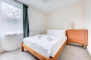een slaapkamer met een bed en een raam bij GuestReady - Harrow Delight near Recreation Ground in Londen