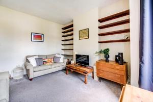 sala de estar con sofá y TV en GuestReady - Harrow Delight near Recreation Ground, en Londres