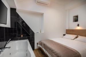 a bedroom with a bed and a bath tub next to a television at Top rooms in Split