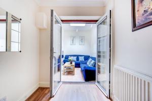 een woonkamer met een blauwe bank en een glazen deur bij GuestReady - Bright Terrace House in Maida Hill in Londen