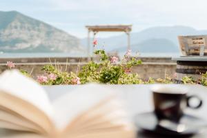 an open book on a table with a flower pot at Camping Del Sole Village in Iseo