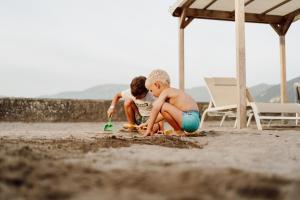 due bambini che giocano nella sabbia sulla spiaggia di Camping Del Sole Village a Iseo