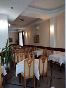 jadalnia z białymi stołami i krzesłami w obiekcie Villa Rimari w Ochrydzie