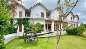 a large white house with a wheel in the yard at Oruwa Boutique Villas in Arugam Bay