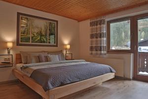 a bedroom with a large bed and two windows at Apartment Alpenwelt in Neustift im Stubaital