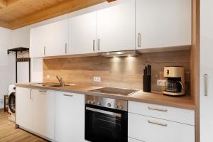 a kitchen with white cabinets and a black appliance at Schwarzwaldglück in Oberkirch