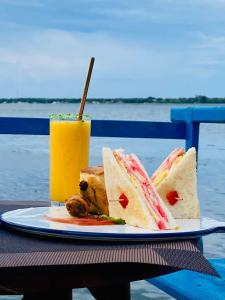 a plate of sandwiches and a drink on a table at Oruwa Boutique Villas in Arugam Bay