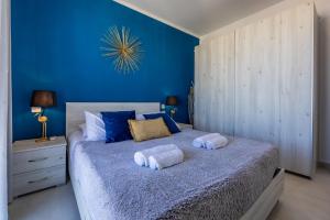 um quarto azul com uma cama com toalhas em II-Kamra ta Golu 5 min walk from St Julians em San Ġwann