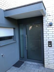 a large glass door on a building with a window at Ferienwohnung 60 m mit hervorragender Aussicht in Talheim