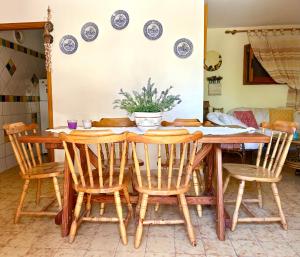 a dining room table and chairs with a potted plant at NURAS - Casa Gea in Stintino +31 photos