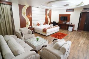 Hotel Sidh Vedantha في باتنا: غرفة معيشة بها كنب ابيض وتلفزيون