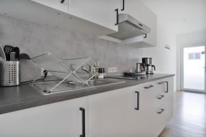 a kitchen with a sink and a counter top at Apartments in the city center I private parking I home2share in Dortmund
