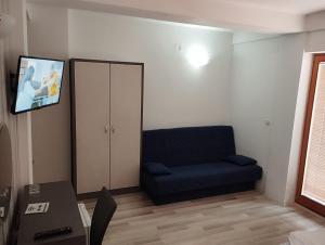 a living room with a blue couch and a tv at Villa Rimari in Ohrid