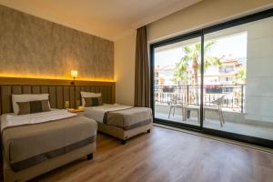 a hotel room with two beds and a large window at DeMANOR HOTEL ADULT ONLY in Alanya +36 photos