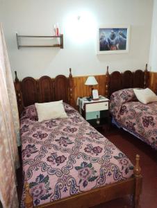 1 dormitorio con 2 camas y mesa con lámpara en Lo de Su en Salta