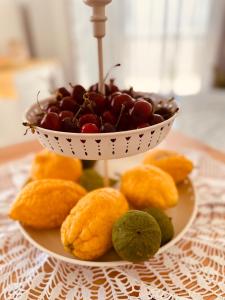 a bowl of cherries on a plate on a table at Domus Angela in Polignano a Mare