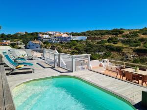 - une piscine sur une terrasse avec une table et des chaises dans l'établissement CASA VERDE - Beach House, Private Terrace & Pool, à Benagil