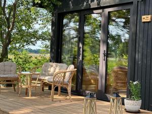 a screened in porch with chairs and a table at Labieši in Jūrmala