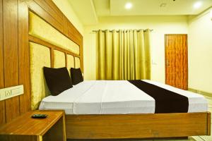 OYO Hotel Grand Signia في Zirakpur: غرفة نوم بسرير كبير وطاولة