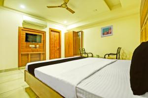OYO Hotel Grand Signia في Zirakpur: غرفة نوم بسرير كبير وتلفزيون