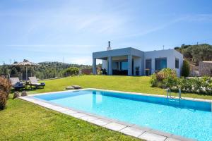 a villa with a swimming pool in front of a house at High View Villa in Afantou