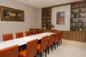 a conference room with a long table and orange chairs at Lanura Saigon Boutique Hotel in Ho Chi Minh City