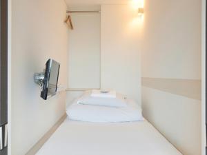 鳥取市にあるドロップイン鳥取のベッド1台とテレビが備わる小さな客室です。