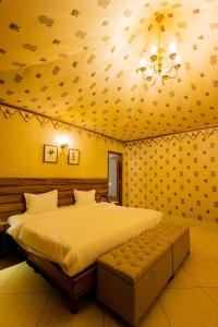 a bedroom with a large bed and a chandelier at Shahpura Gandharva Retreat, Sariska in Alwar