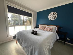 a bedroom with a bed with shoes on it at Wombat Forest Country Retreat in Trentham East