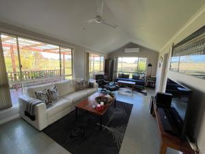 a living room with a white couch and a table at Wombat Forest Country Retreat in Trentham East