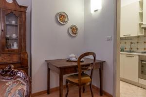 a kitchen with a wooden table and a chair at HouSmart Cartoleria 8 in Bologna +26 photos