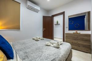 een slaapkamer met twee paar schoenen op een bed bij Dorris's Apartment 5 min walk from St Julians in San Ġwann