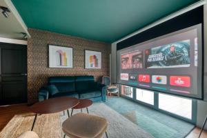 a living room with a couch and a tv at GuestReady - Apt près du Parc de la Tête d'Or in Lyon