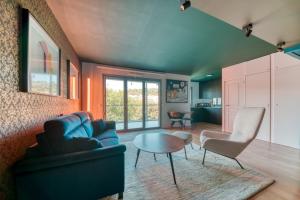 GuestReady - Apt près du Parc de la Tête d'Or في ليون: غرفة معيشة مع أريكة زرقاء وطاولة
