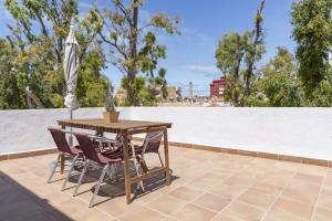 a table and chairs on a patio with an umbrella at Luminoso y amplio piso en Chipiona 5 in Chipiona