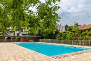 una grande piscina blu con recinzione e alberi di GuestReady - Serene Refuge with a shared pool a Garches