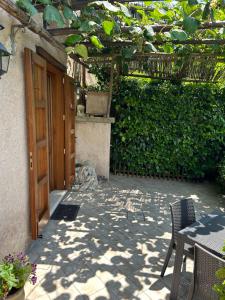 un patio al aire libre con una puerta de madera y sillas en Agriturismo Orrido di Pino en Agerola