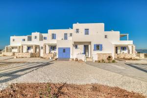 a large white house with a blue door at Paros Sea View Eco - Aetherian Ciel Villas, Cymo in Mármara