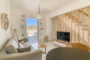 a living room with a couch and a tv at Paros Sea View Eco - Aetherian Ciel Villas, Cymo in Mármara