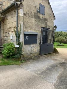 eine Tür zu einem Gebäude mit einem Schild darauf in der Unterkunft La Ferme de Valeuse in Morienval