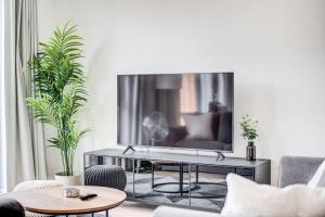 un soggiorno con una grande TV a parete di GuestReady - Olympic Park City Living a Londra
